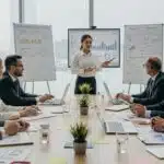 Equipe de executivos em reunião de gestão empresarial com gráficos e estratégias de planejamento